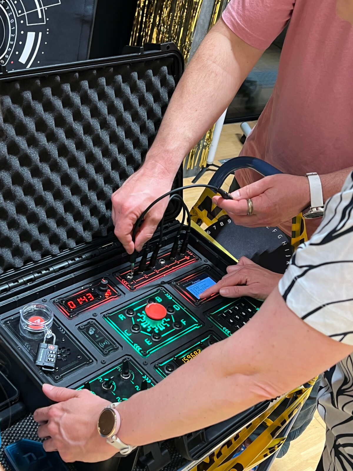Close-up of hands connecting cables during the escape game